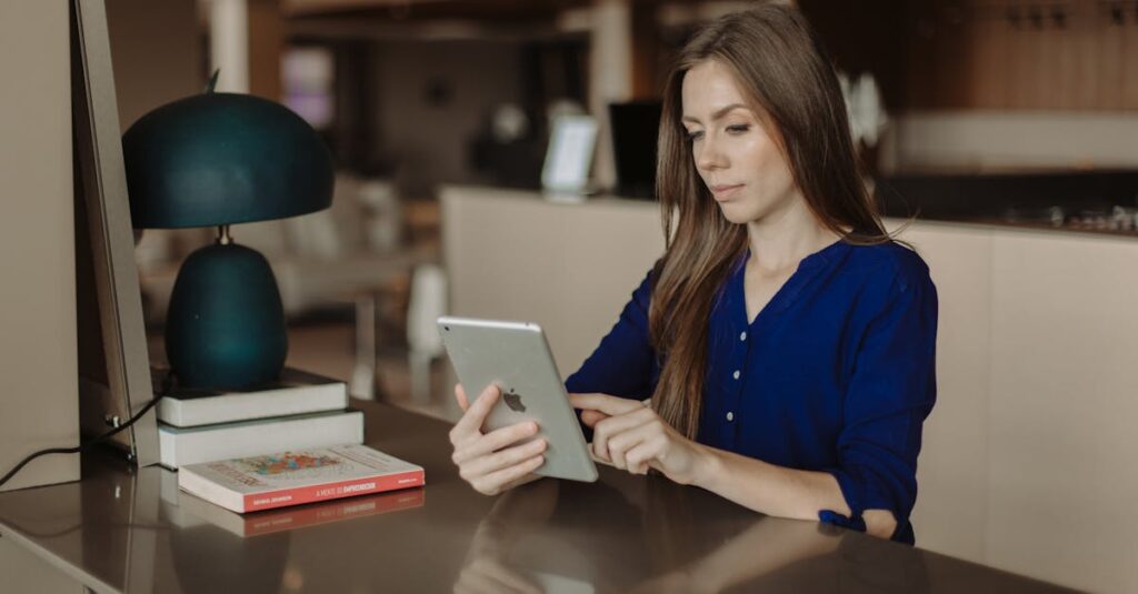 Lectrice consultant un livre numérique sur une tablette, à côté de livres imprimés